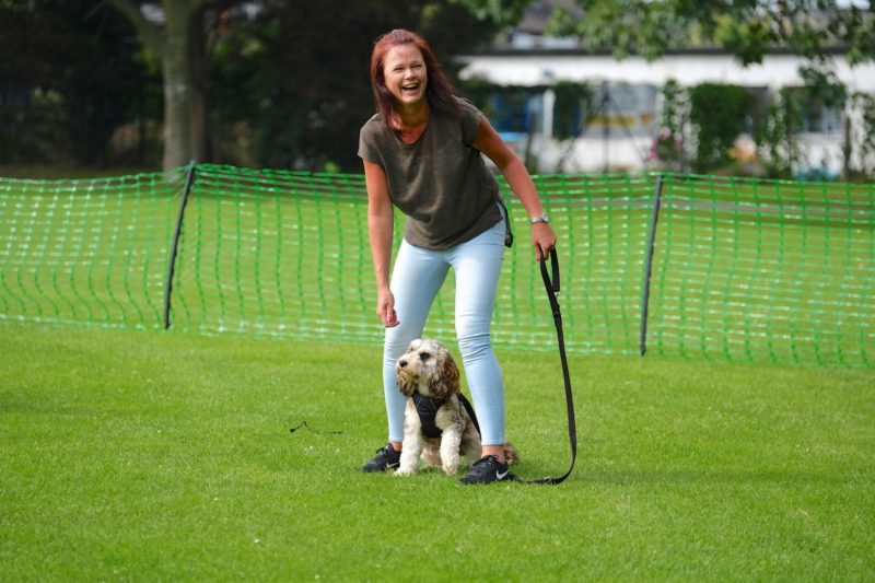 lady enjoying and laughing with dog in middle game